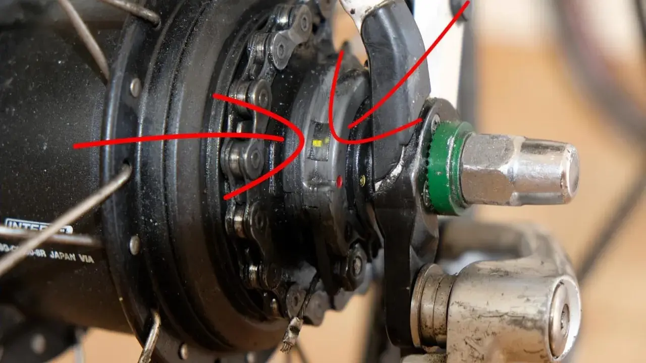 Rote Pfeile zeigen auf die Markierungen zum shimano nexus 8 einstellen. Nahaufnahme einer Nabenschaltung.