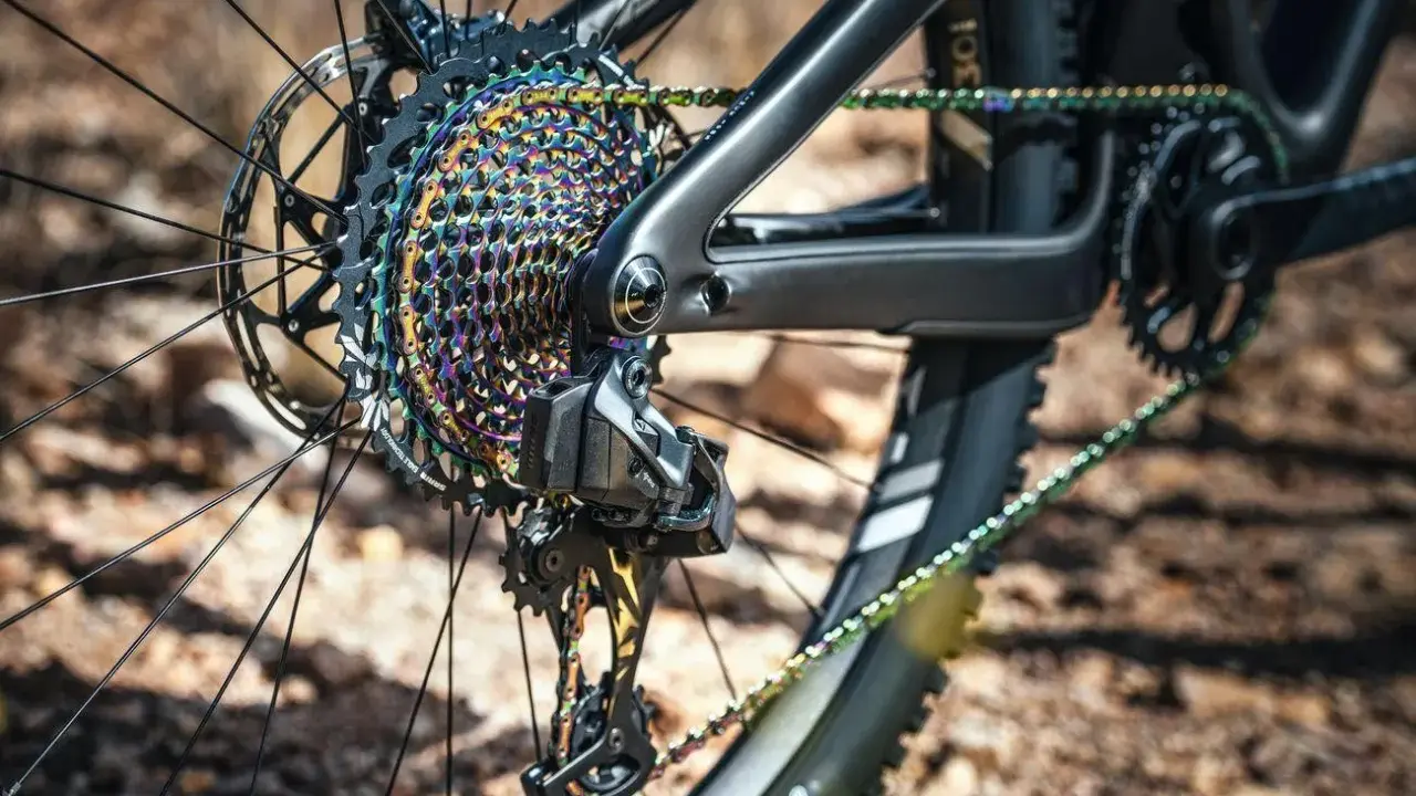Nahaufnahme des farbenfrohen Zahnkranzes und der Kette eines Mountainbikes. Ein Mechaniker bereitet sich darauf vor, die Fahrradkette zu wechseln, um die Leistung zu optimieren.
