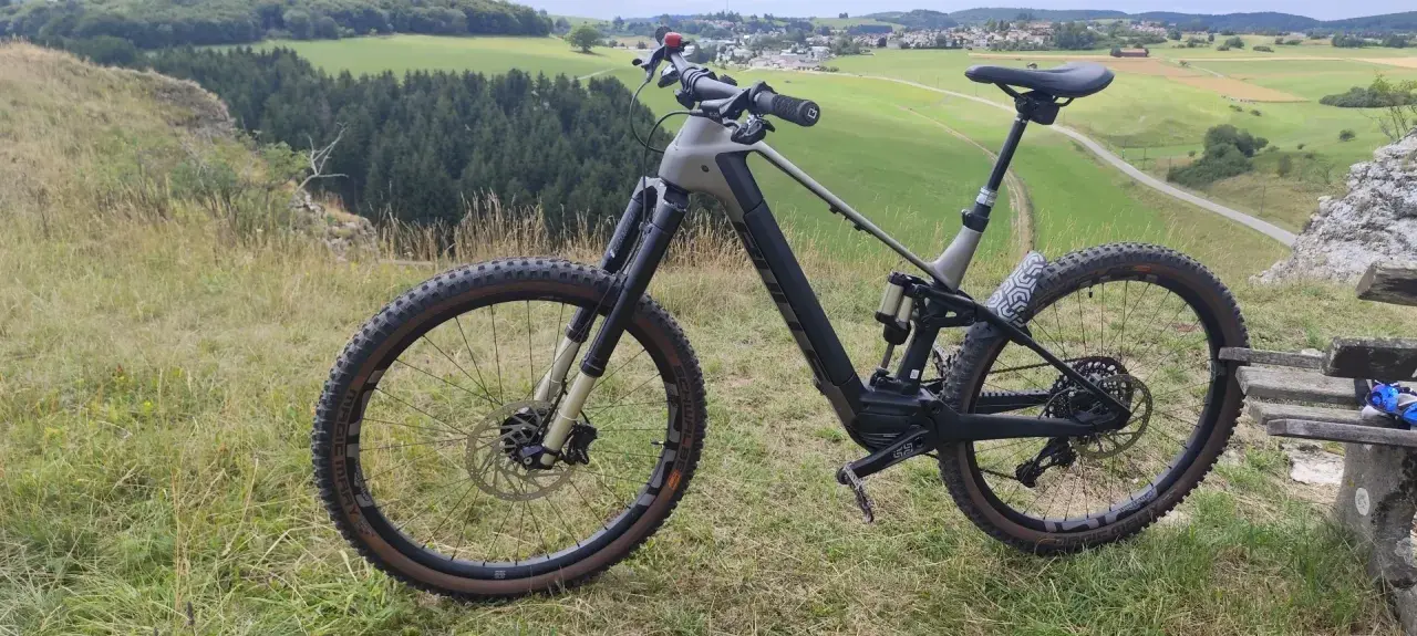 Ein E-Bike steht auf einem Hügel mit Blick auf grüne Felder und Wälder. Perfekt für eine Tour mit dem e-bike auf den Brocken.