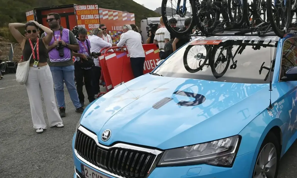 Blaues Auto mit Fahrrädern auf dem Dach, bereit für ein Rennen. Auf der Motorhaube steht "PREMIER TECH", ein Zeichen für israelische Spitzentechnologie im Radsport.