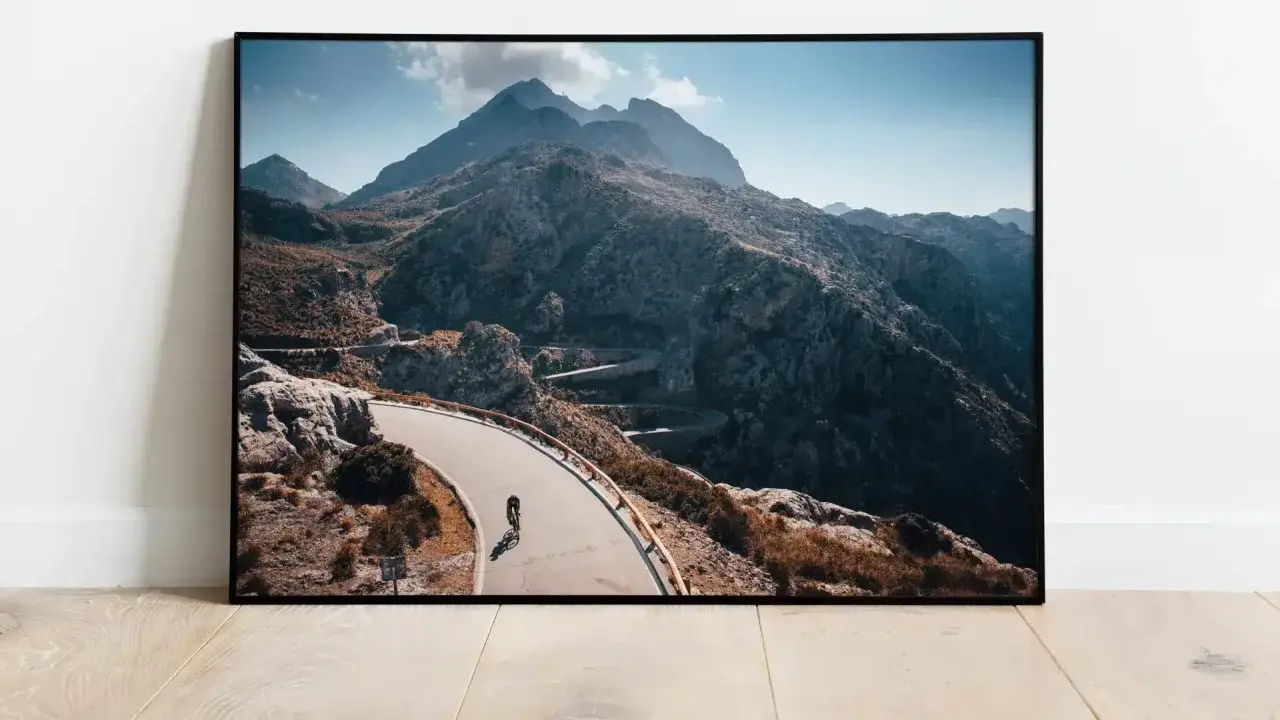Ein Rennradfahrer bezwingt die Serpentinen der Sa Calobra-Straße auf Mallorca. Majestätische Berge im Hintergrund.