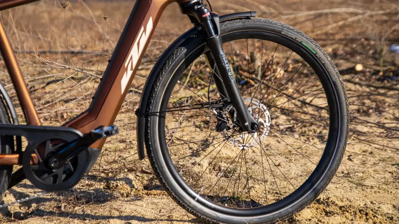 Vorderreifen und Federgabel eines braunen KTM Macina Style E-Bikes. Der Unterschied zwischen dem KTM Macina Style 720 und 730 liegt in den Details.