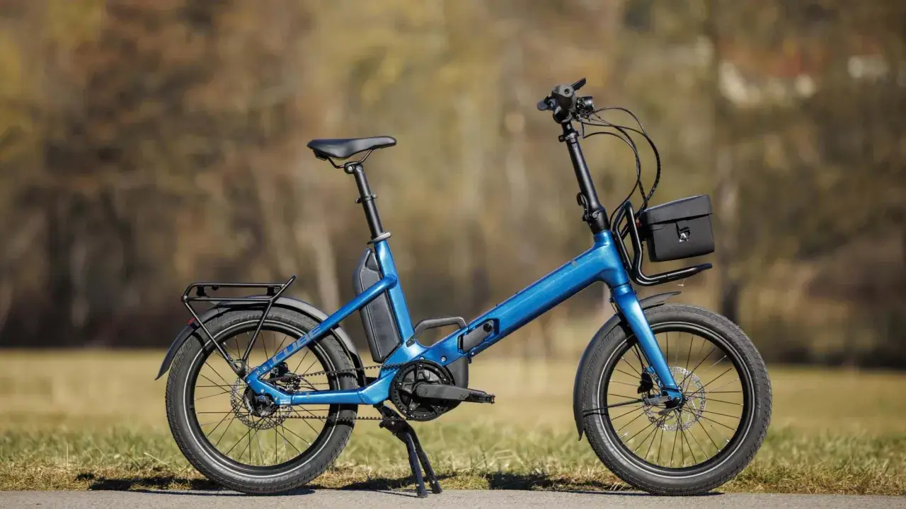 Blaues Cube Fold Hybrid 500 E-Bike im Test, mit Gepäckträger und Tasche.