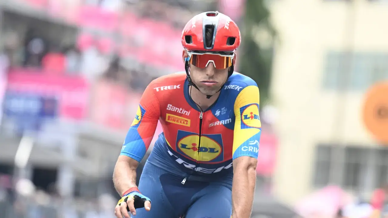 Carlos Verona im roten und blauen Radtrikot mit Lidl-Logo, konzentriert auf dem Rad.