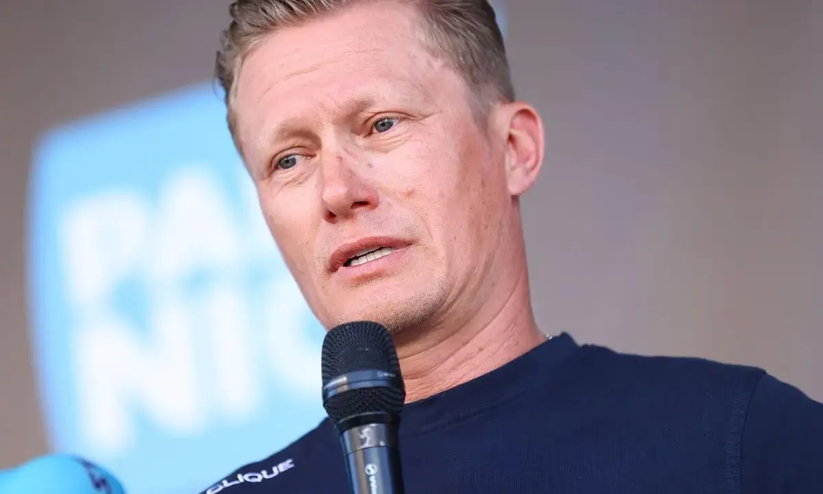 Alexander Vinokurov spricht ins Mikrofon, trägt ein Trikot des Astana Teams.