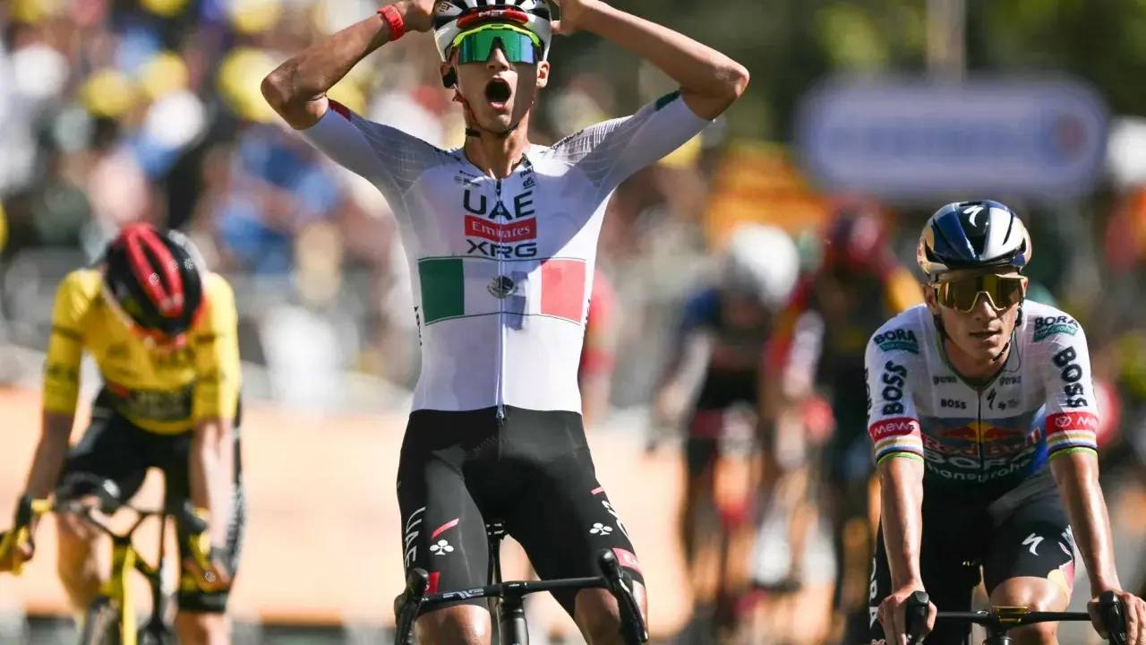 Radfahrer jubelt nach Etappensieg bei der Tour de France. So funktioniert die Tour de France: Ausdauer, Strategie und ein Hauch von Glück entscheiden.