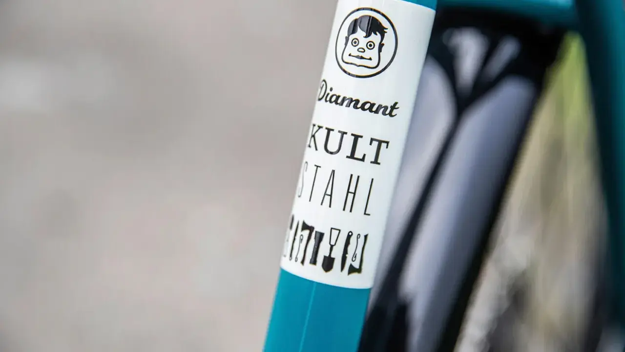 Ein **Diamant**-Fahrrad mit dem Schriftzug "KULT STAHL" und einem lustigen Comic-Gesicht.