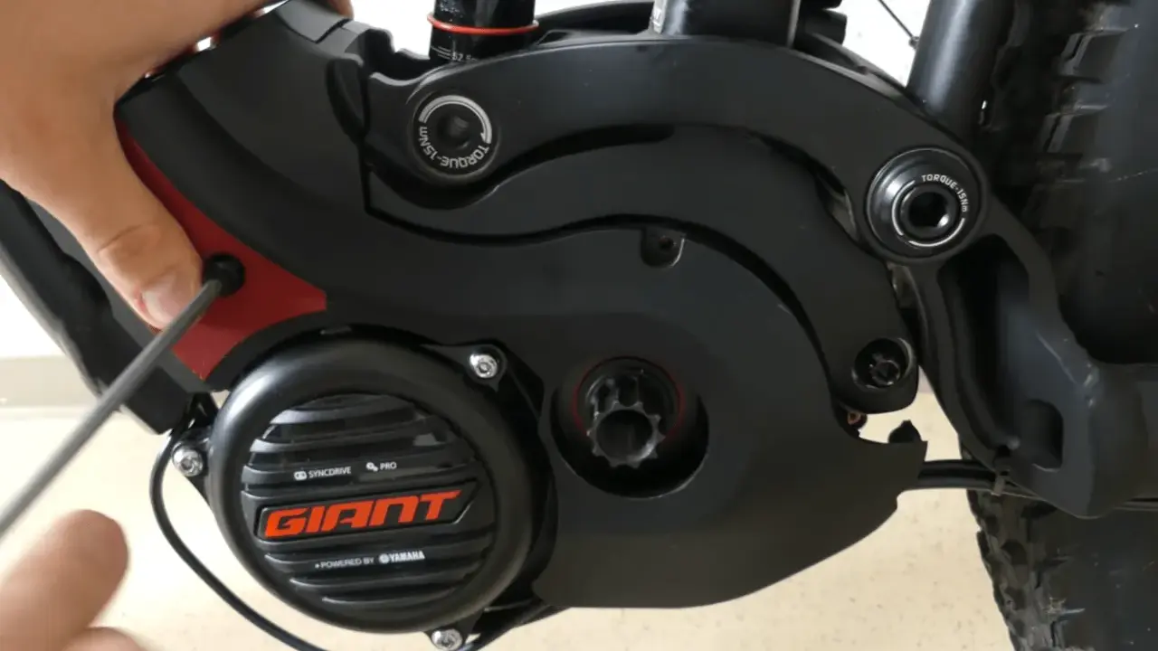 Hand schraubt am Giant SyncDrive Sport Motor. Mögliche Probleme mit dem E-Bike Antrieb.