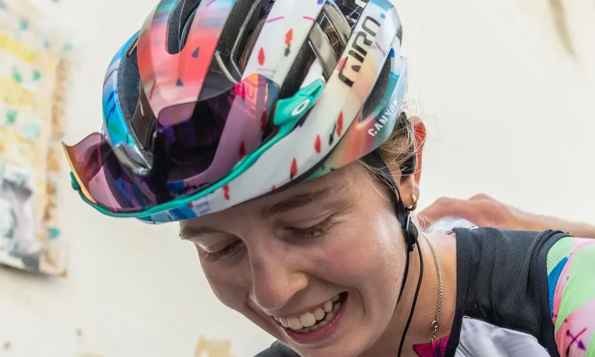 Lachende Antonia Niedermaier mit buntem Helm und Brille, bereit für das nächste Rennen.