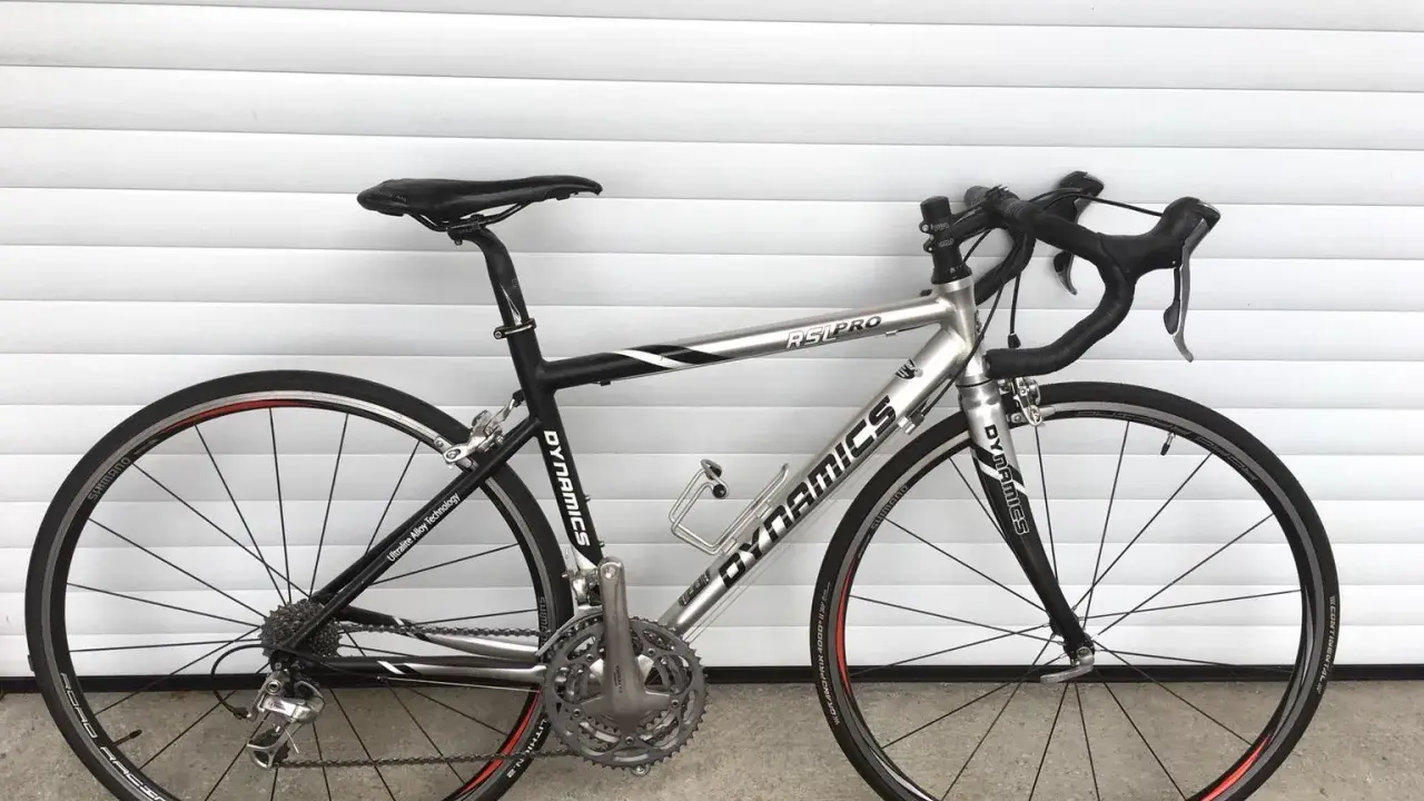 Silbernes Rennrad DYNAMICS RSL COMP mit schwarzen Akzenten, bereit für die nächste Fahrt.