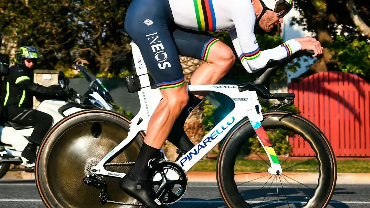 Filippo Ganna im Zeitfahr-Trikot mit Regenbogenstreifen auf seinem Pinarello-Rad, bereit für Höchstleistungen.