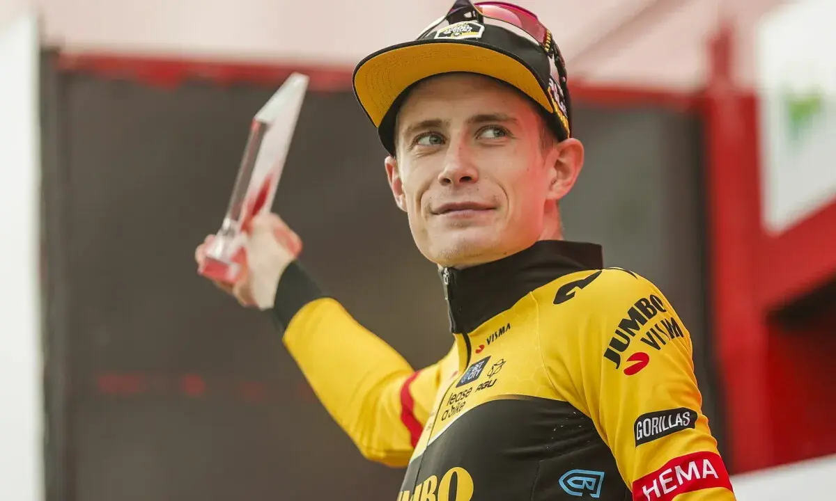 Jonas Vingegaard, strahlend mit einer Trophäe, trägt sein gelbes Jumbo-Visma Trikot.