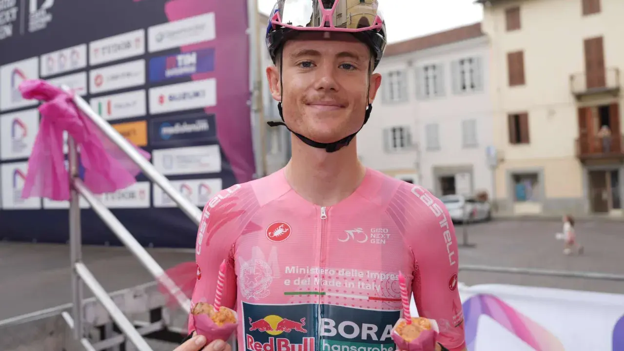 Radfahrer des Teams Red Bull Bora Hansgrohe hält einen Muffin mit Kerze.