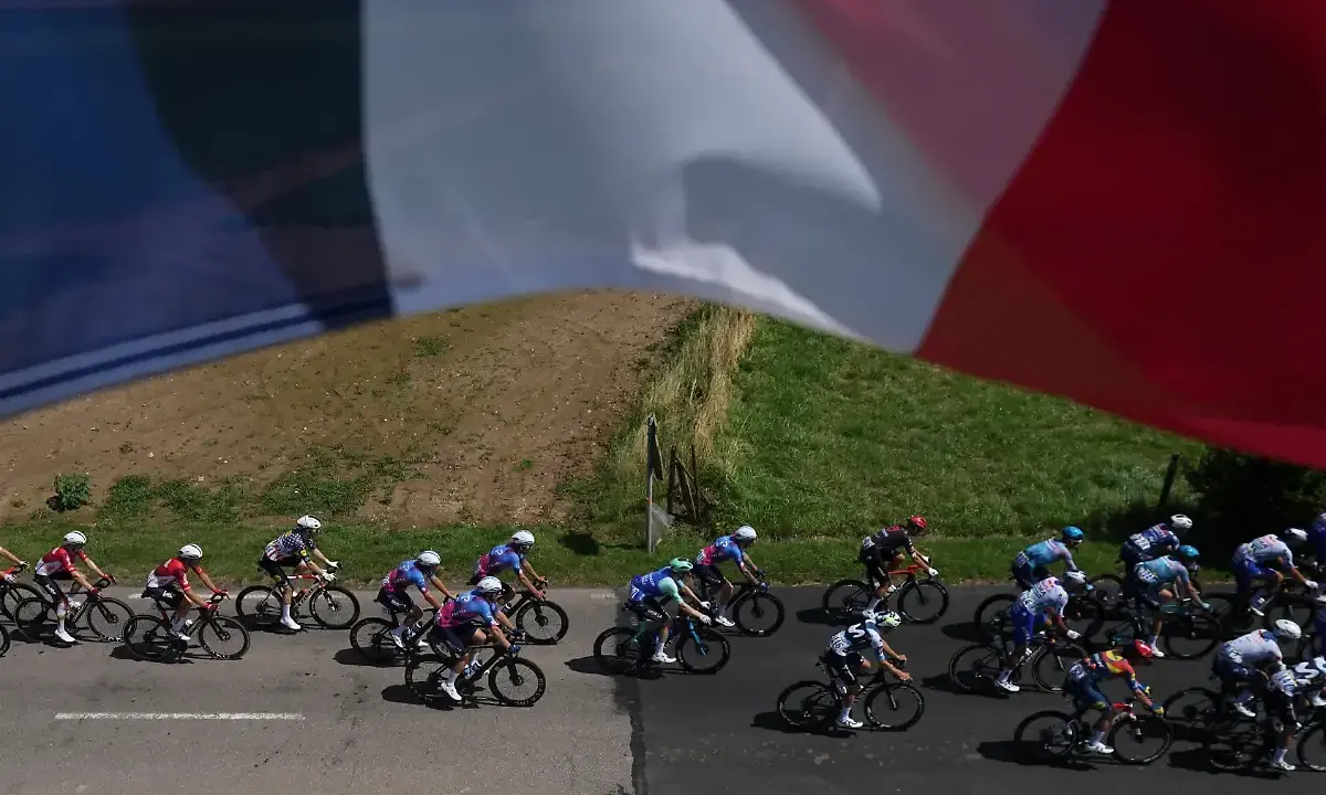 Radfahrer im Peloton, die französische Flagge weht im Wind. Ein spannender Moment am Tour de France Ende.