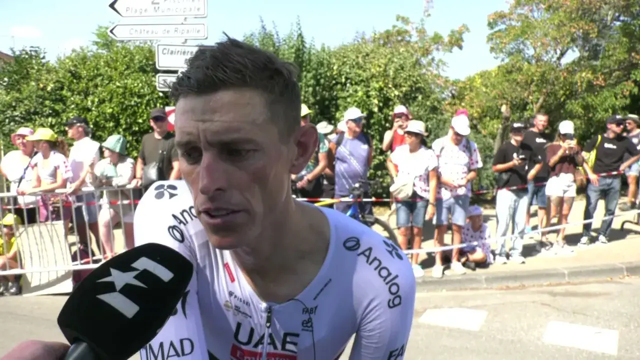 Brandon McNulty, Radfahrer im UAE-Trikot, gibt ein Interview. Im Hintergrund stehen Zuschauer und Straßenschilder.