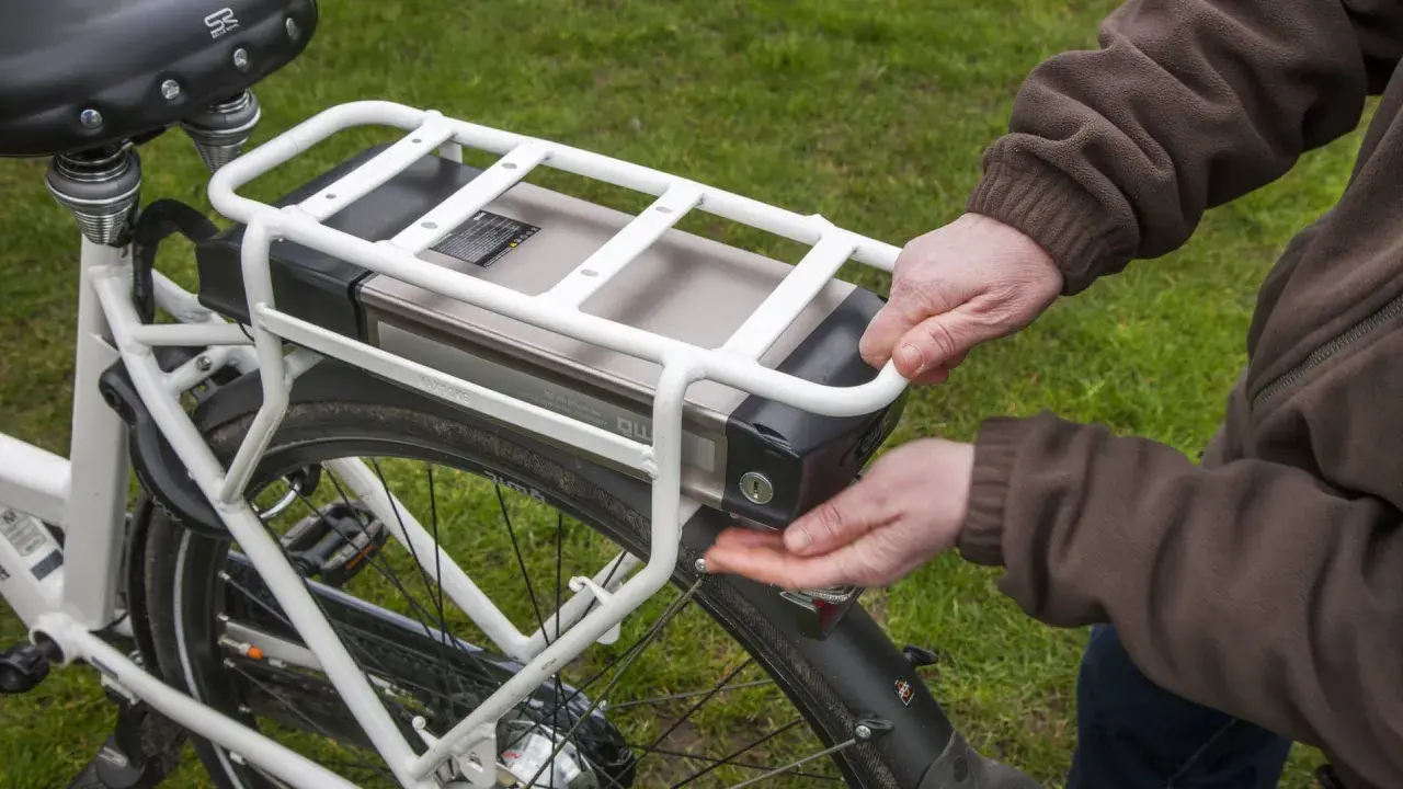 Hände lösen den Akku eines E-Bikes. Korrektes e bike akku entsorgen ist wichtig für die Umwelt.