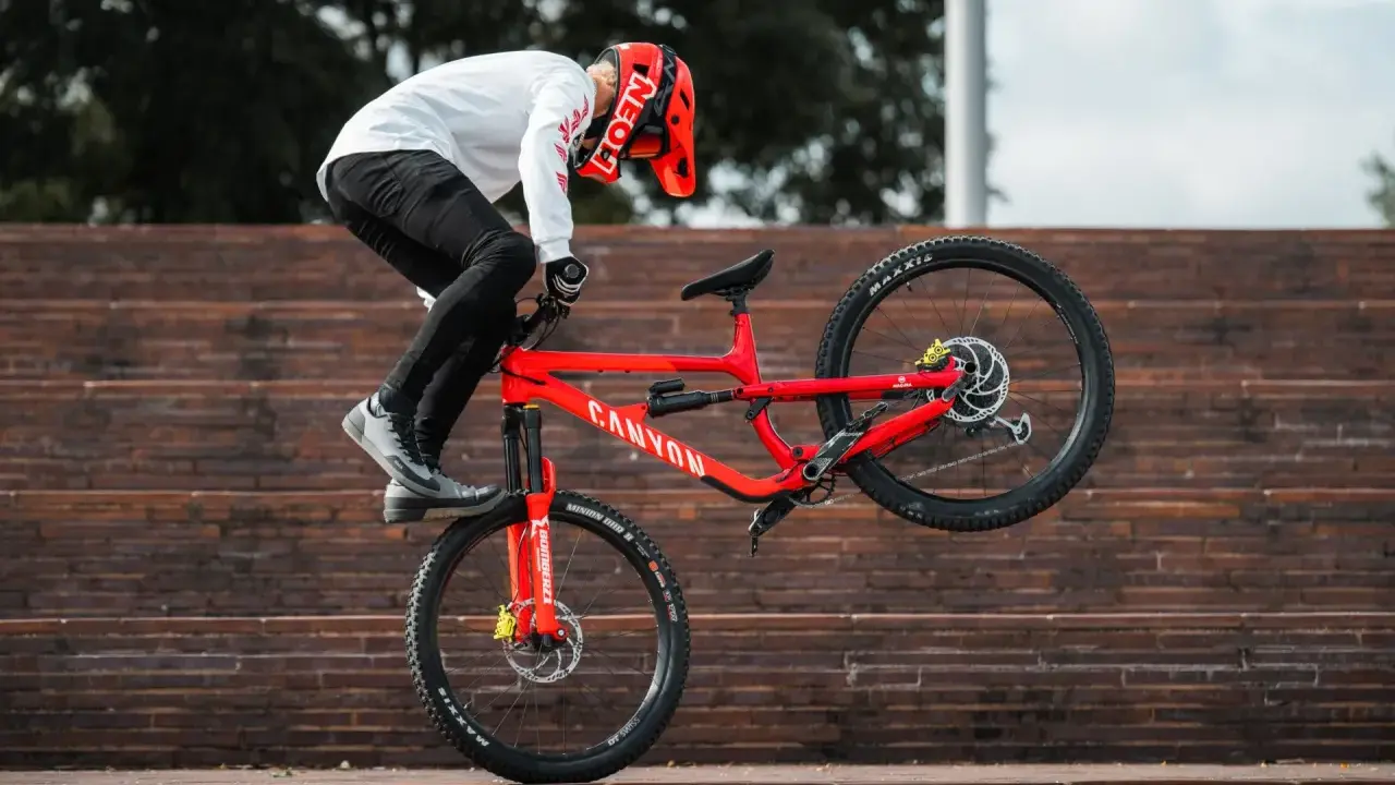 Gabriel Wibmer balanciert auf seinem roten Canyon Bike auf einer Treppe.