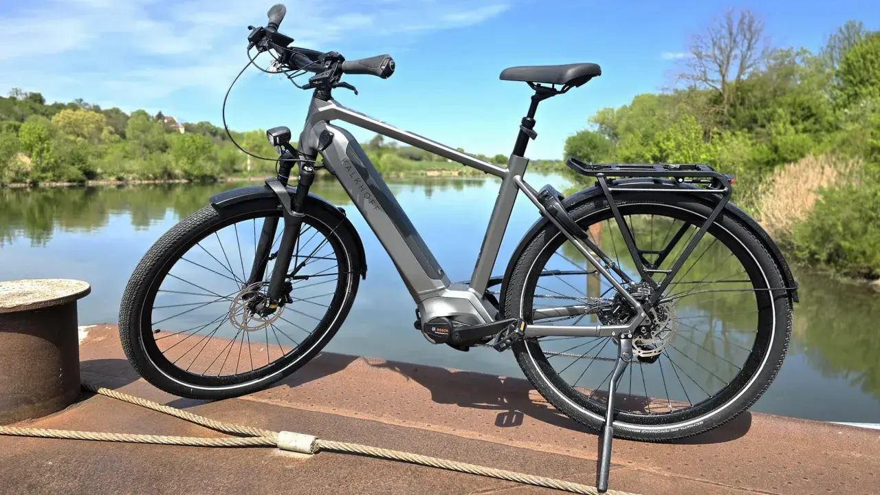 Graues E-Bike am Wasser. Die Preisentwicklung von E-Bikes ist spannend, dieses Modell bietet Komfort und Leistung.