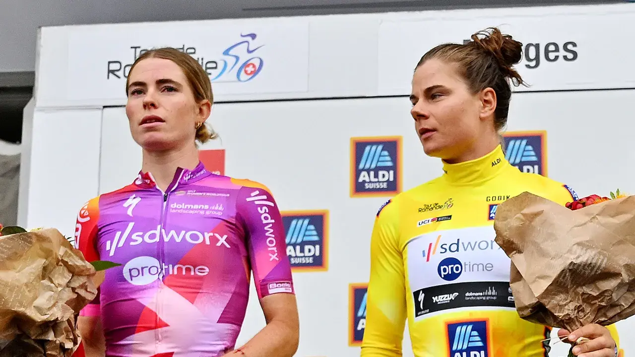 Lotte Kopecky auf dem Podium, sie trägt ein pink-violettes Trikot. Neben ihr eine Fahrerin im gelben Trikot.
