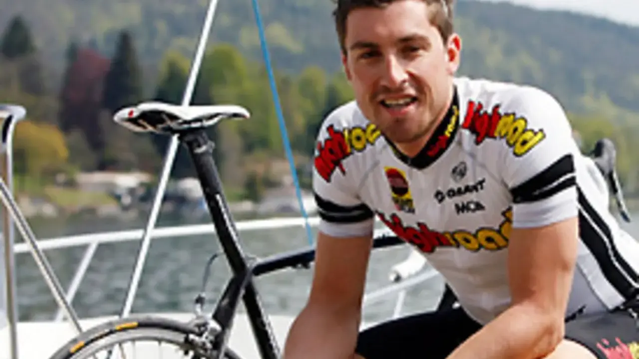 Bernie Eisel, Radsportler, lächelt neben seinem Rennrad auf einem Boot.