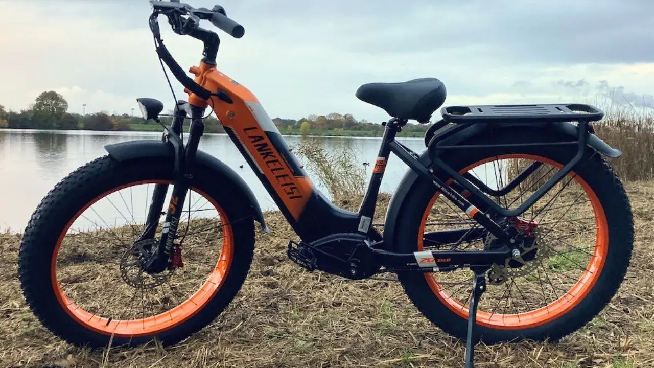 Orange-schwarzes E-Bike mit breiten Reifen am Seeufer. Gute Lankeleisi Erfahrungen sind garantiert mit diesem robusten Fatbike.