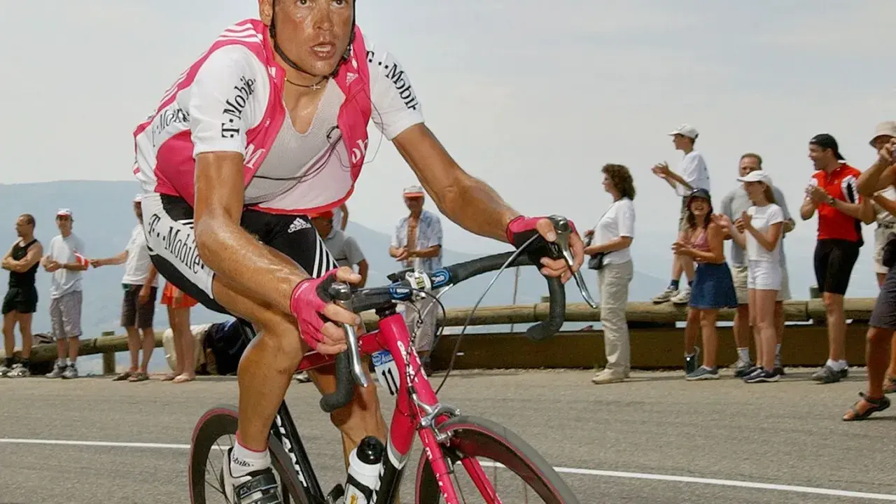 Jan Ullrich auf Mallorca, im T-Mobile-Trikot, kämpft sich bergauf. Zuschauer feuern ihn an.