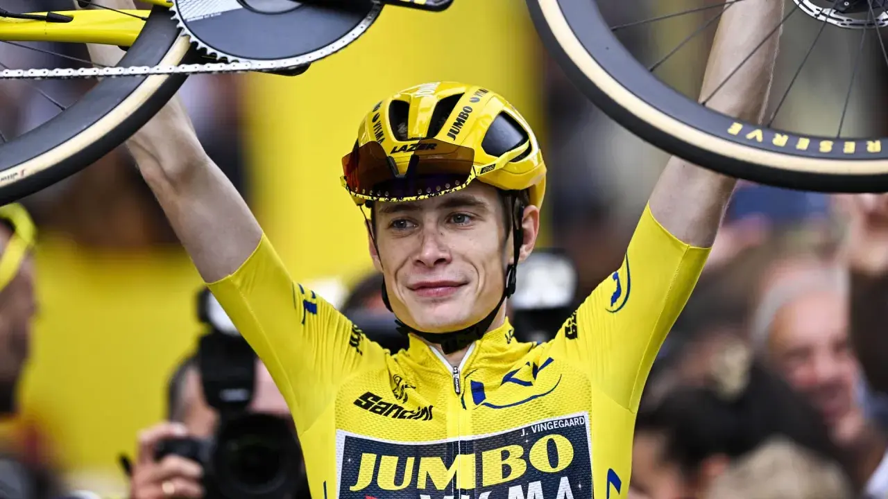 Jonas Vingegaard im Gelben Trikot, mit seinem Rad über dem Kopf. Sein Gehalt ist wohl hoch, bei diesem Erfolg!