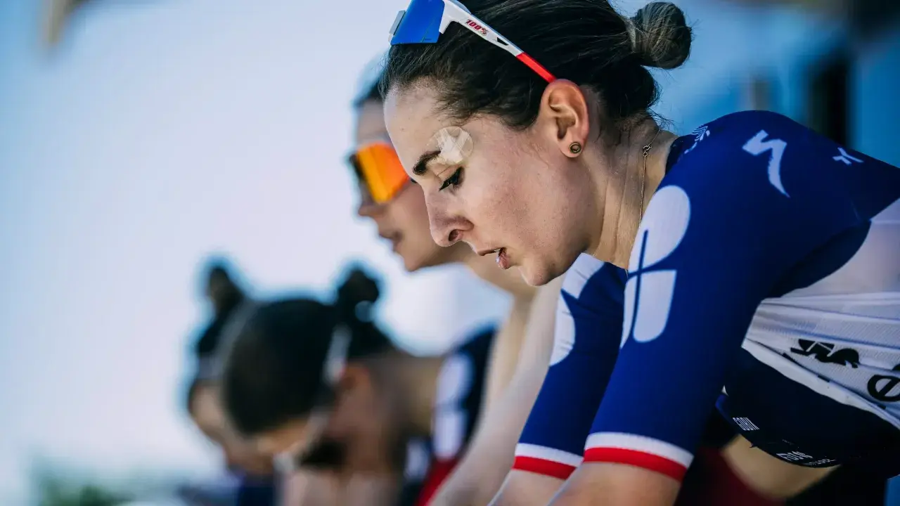 Juliette Labous, mit Pflaster auf der Stirn, konzentriert sich vor dem Rennen. Ihre Teamkolleginnen sind im Hintergrund zu sehen.