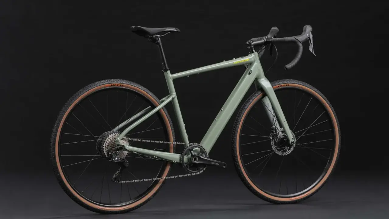 Grünes Cannondale Topstone Neo SL 2 Gravelbike mit braunen Reifen. Das geringe cannondale topstone neo sl 2 gewicht macht es agil.