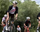Radfahrer im Rennen bei der Dauphiné Rundfahrt. Ein Fahrer in weißem Trikot mit "AG2R CITROEN" Aufschrift fährt bergauf.