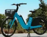 Ein blaues Bird E-Bike mit Korb steht im Freien. Gute Bird Bike Erfahrungen sind garantiert, wenn man die Stadt so erkundet.
