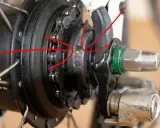 Rote Pfeile zeigen auf die Markierungen zum shimano nexus 8 einstellen. Nahaufnahme einer Nabenschaltung.