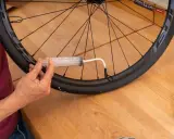 Mit einer Spritze wird Dichtmilch in den Tubeless Reifen gefüllt. So gelingt das tubeless reifen montieren.