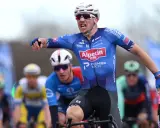 Henri Uhlig jubelt im Radsportrennen, seine Arme ausgestreckt, während er auf dem Rad sitzt.