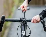 Hände stellen den MTB Lenker ein. Mit einem Schraubenzieher wird die Lenkerposition justiert, um die perfekte Fahrt zu ermöglichen.