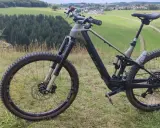 Ein E-Bike steht auf einem Hügel mit Blick auf grüne Felder und Wälder. Perfekt für eine Tour mit dem e-bike auf den Brocken.