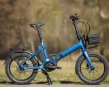 Blaues Cube Fold Hybrid 500 E-Bike im Test, mit Gepäckträger und Tasche.