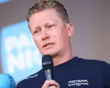 Alexander Vinokurov spricht ins Mikrofon, trägt ein Trikot des Astana Teams.
