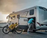 Zwei Personen laden Mountainbikes in einen Hymer Wohnwagen. Perfekt für Abenteuer mit dem e-bike wohnwagen.