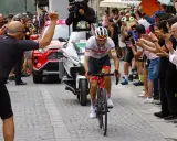 Giulio Ciccone fährt auf seinem Rennrad durch eine Gasse, umgeben von jubelnden Zuschauern und Motorrädern.