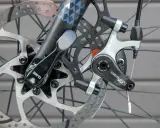 Nahaufnahme einer Fahrradscheibenbremse. Die Bremsbeläge sind sichtbar, was einen Hinweis darauf gibt, wann bremsscheiben wechseln.