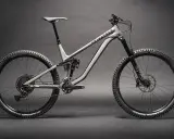 Ein graues Fullsuspension-Mountainbike der Marke Privateer steht auf dunklem Grund. Dieses Bike ist bereit für jedes Abenteuer.