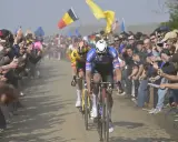 Zwei Radprofis kämpfen auf staubiger Strecke, umringt von jubelnden Fans. Die Spannung steigt, doch die Frage nach fairem Wettkampf und Doping im Radsport bleibt.