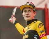 Jonas Vingegaard, strahlend mit einer Trophäe, trägt sein gelbes Jumbo-Visma Trikot.