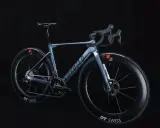 Ein elegantes, hellblaues Rennrad, das myvelo Verona, steht vor schwarzem Hintergrund. Seine aerodynamischen Felgen und die schlanke Silhouette versprechen Geschwindigkeit.