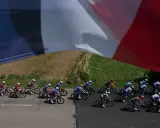 Radfahrer im Peloton, die französische Flagge weht im Wind. Ein spannender Moment am Tour de France Ende.