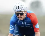 David Gaudu im blauen und roten Trikot, mit Helm und Sonnenbrille, konzentriert sich auf das Rennen.