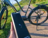 E-Bike Akku wird abgenommen, um das E-Bike zu reinigen. Die Sonne scheint auf die Weinberge.