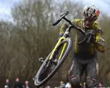 Wout van Aert kämpft sich im Schlamm durch ein hartes Cyclocross-Rennen, sein Körper und Rad sind komplett mit Dreck bedeckt.
