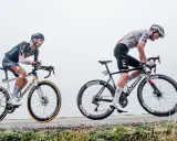 Pavel Sivakov kämpft sich auf seinem Rad einen nebligen Anstieg hinauf, während ein Konkurrent im UAE-Trikot neben ihm fährt.